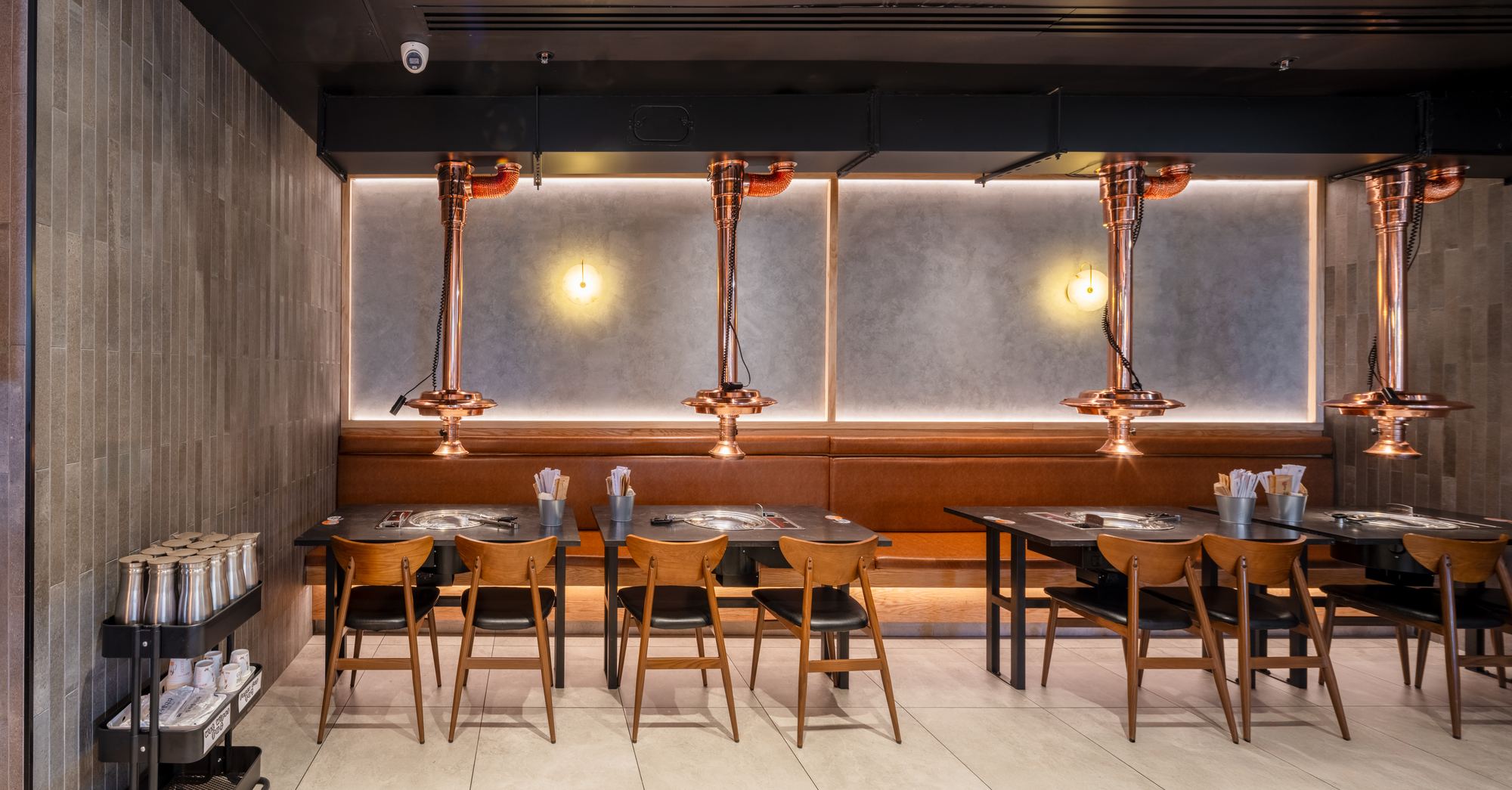 Tan leather booths beneath copper extraction hoods